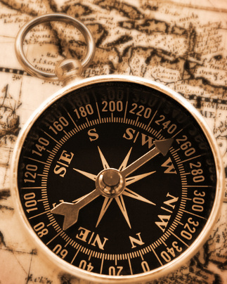 old-fashioned compass on vintage map with warm yellow lighting